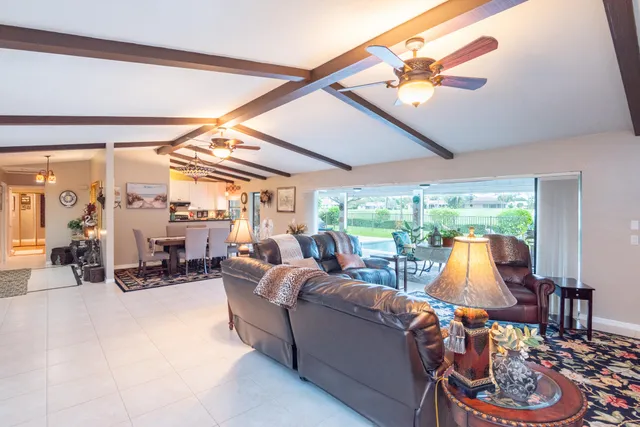 a living room with a bed furniture flat screen tv and a large window