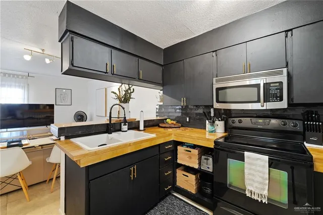 a kitchen with stainless steel appliances kitchen island granite countertop a refrigerator a stove and a sink with wooden floor