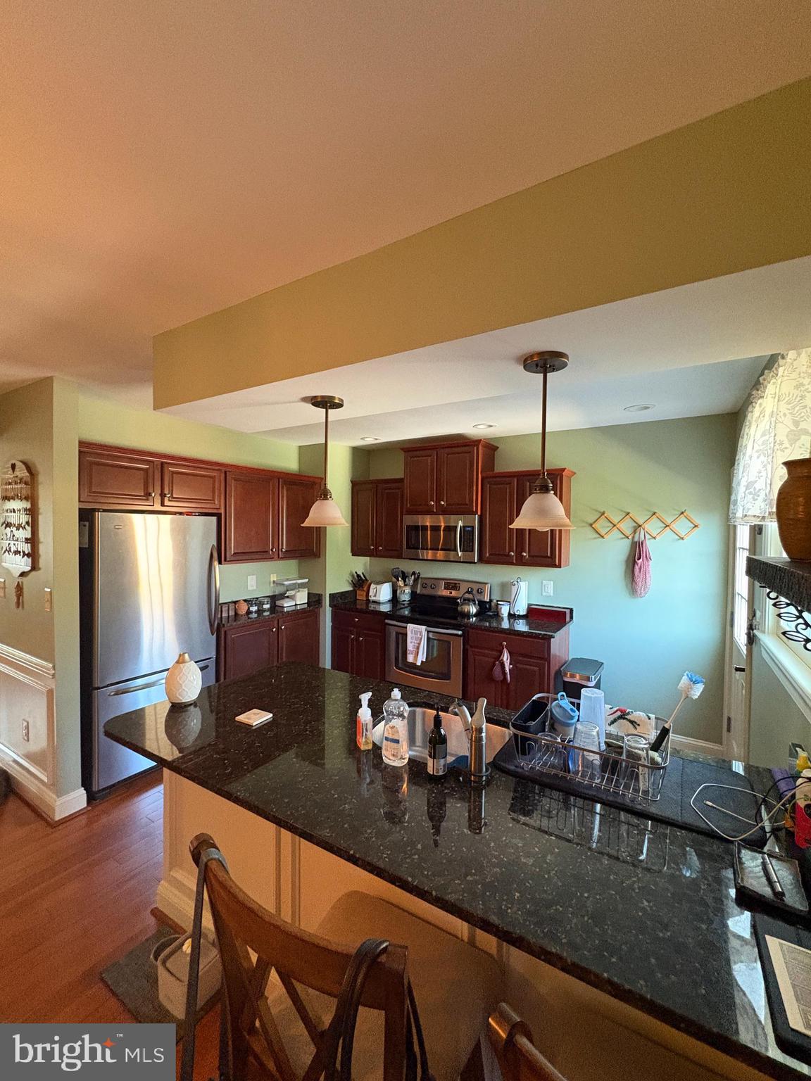 225 East 5th Street Frederick, MD 21701 - Photo 12 of 20 a kitchen with a table chairs and flat screen tv