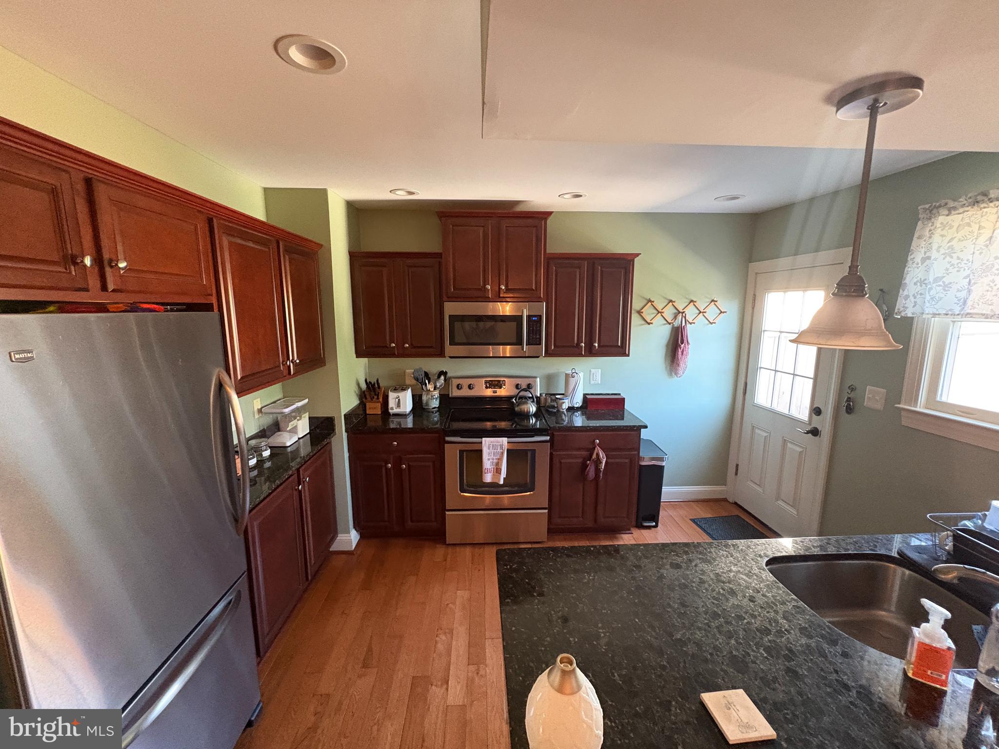 225 East 5th Street Frederick, MD 21701 - Photo 3 of 20 a kitchen with stainless steel appliances granite countertop a refrigerator stove top oven a sink and dishwasher