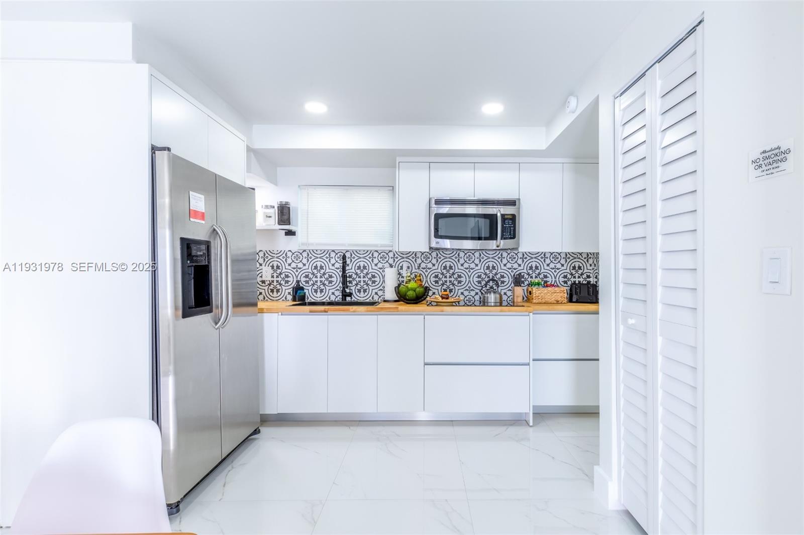 2242 Northwest 64th Street Miami, FL 33147 - Photo 14 of 16 a kitchen with stainless steel appliances a refrigerator sink and microwave