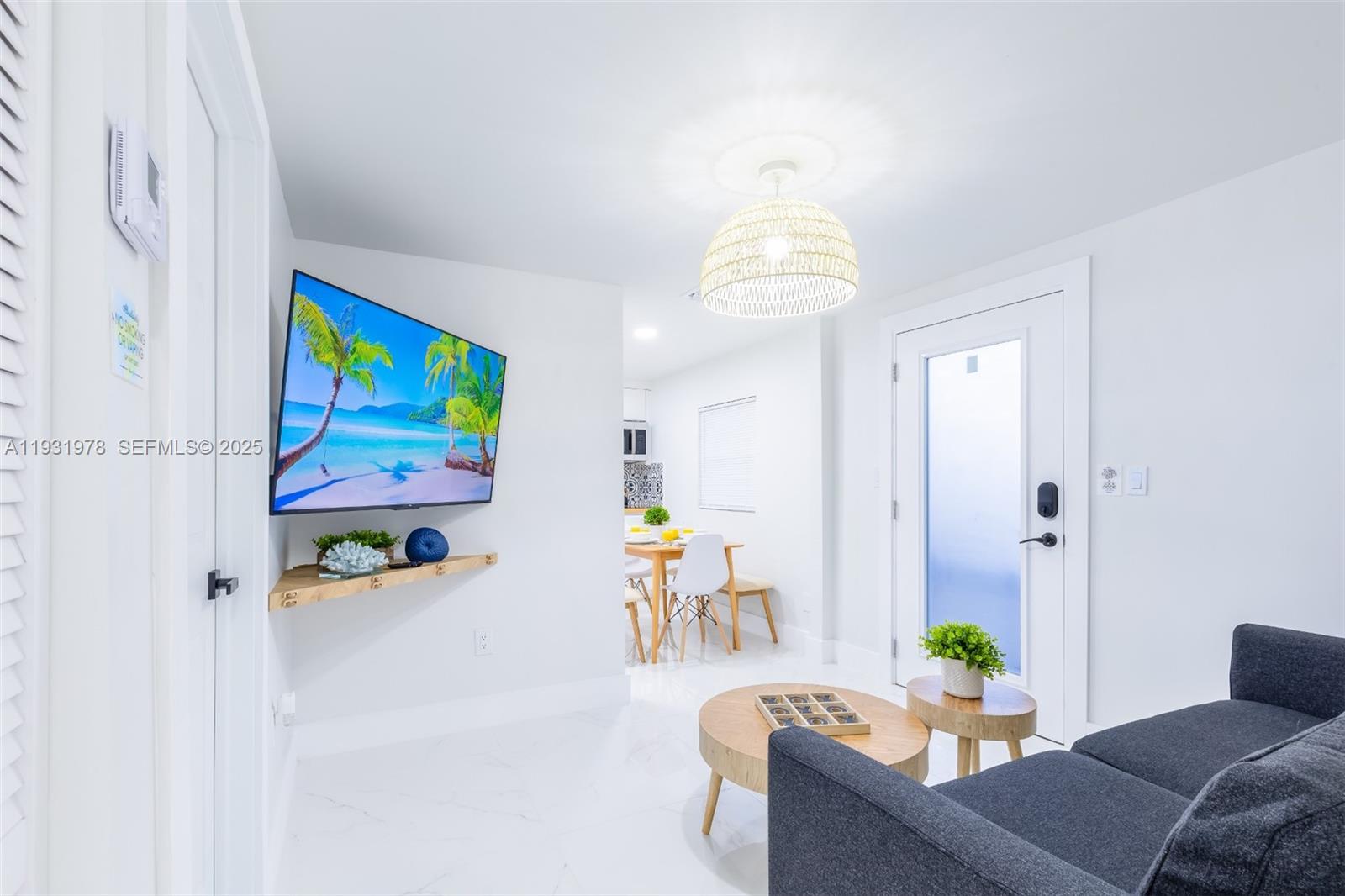 2242 Northwest 64th Street Miami, FL 33147 - Photo 8 of 16 a living room with furniture and a chandelier