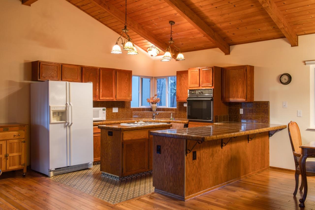 4041 Costado Road Pebble Beach, CA 93953 - Photo 3 of 4 a kitchen with stainless steel appliances granite countertop a stove a refrigerator a sink dishwasher and wooden cabinets with wooden floor
