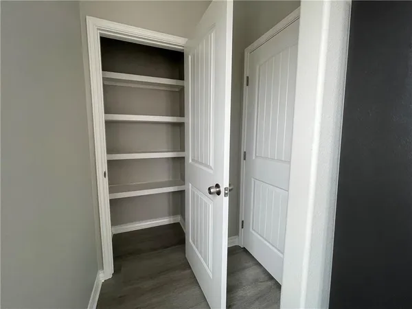 a view of walk in closet with empty racks