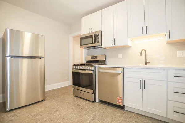a kitchen with white cabinets and white appliances