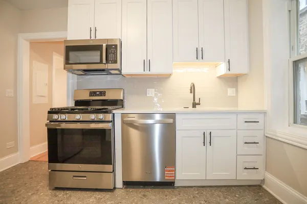 a bathroom with a granite countertop sink and a window