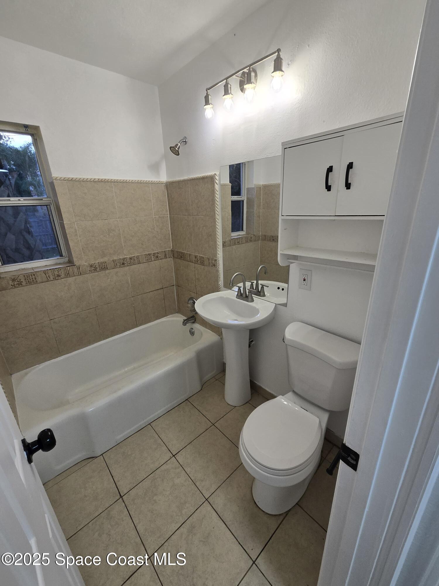 513 North Georgia Avenue Cocoa, FL 32922 - Photo 18 of 20 a white toilet sitting next to a bathroom sink and tub