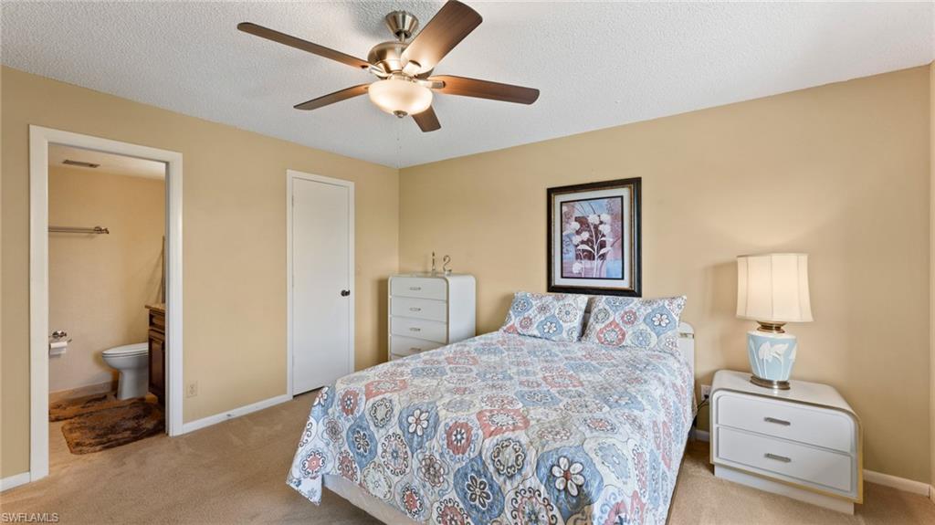 45 High Point Circle South, Unit 304 Naples, FL 34103 - Photo 11 of 20 a bedroom with a large bed and a chandelier