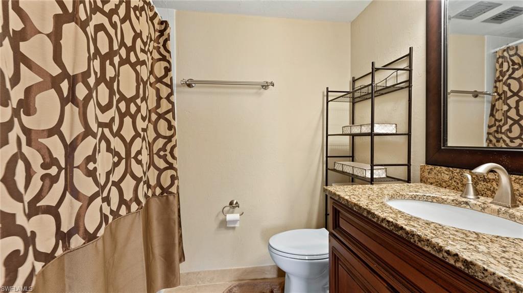 45 High Point Circle South, Unit 304 Naples, FL 34103 - Photo 12 of 20 a bathroom with a granite countertop sink and a mirror