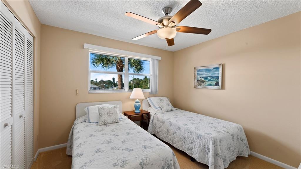 45 High Point Circle South, Unit 304 Naples, FL 34103 - Photo 13 of 20 a bedroom with bed and a large window