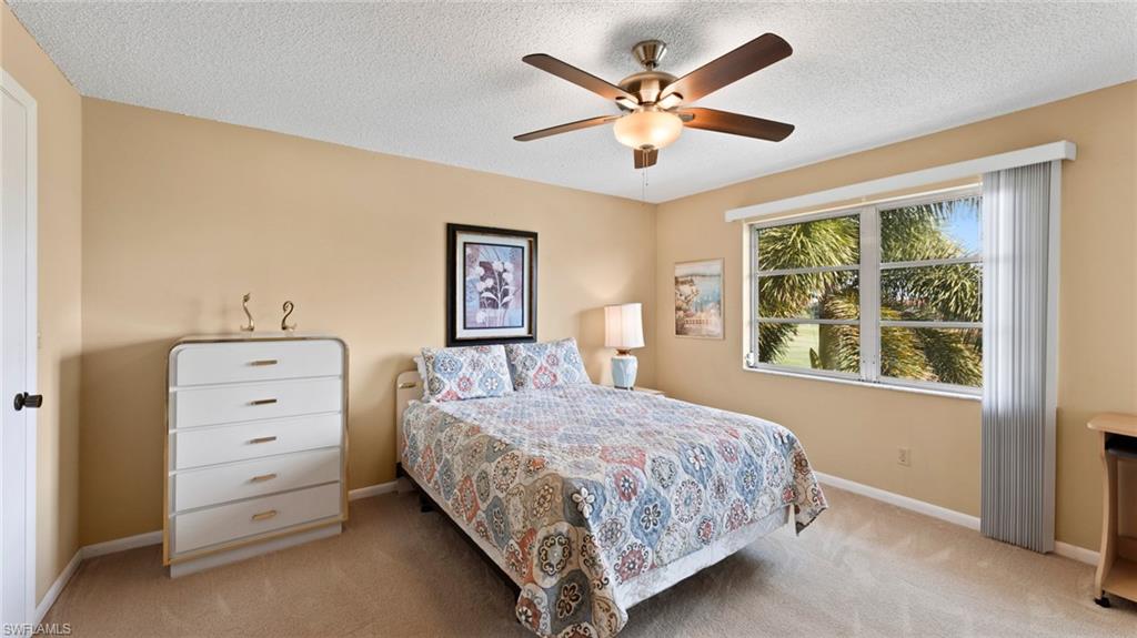 45 High Point Circle South, Unit 304 Naples, FL 34103 - Photo 10 of 20 a bedroom with a bed and a dresser