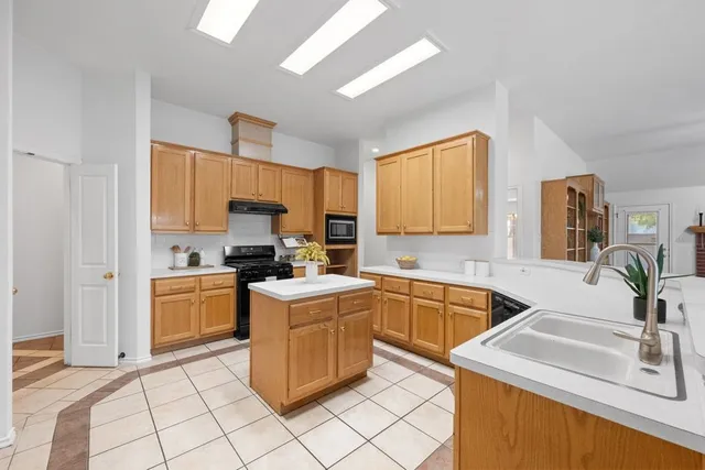 a kitchen with a sink stove top oven and refrigerator