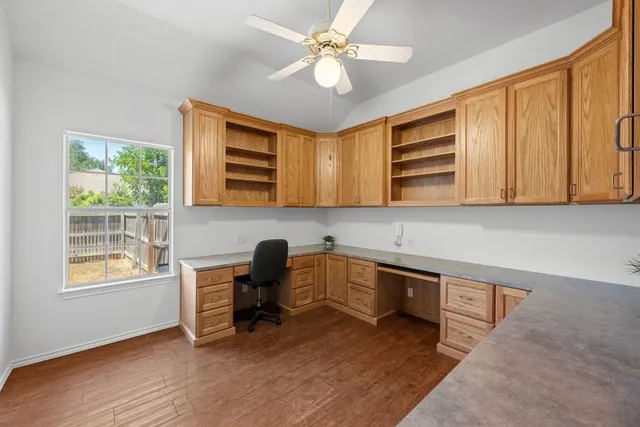 a view of a workspace with furniture and a window