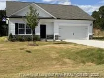 a view of yellow house with swimming pool in front of it