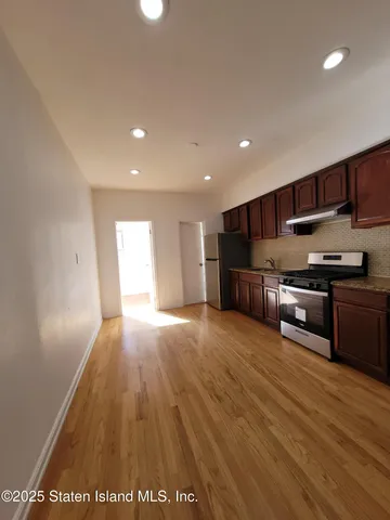 a kitchen with wooden floors and wooden cabinets