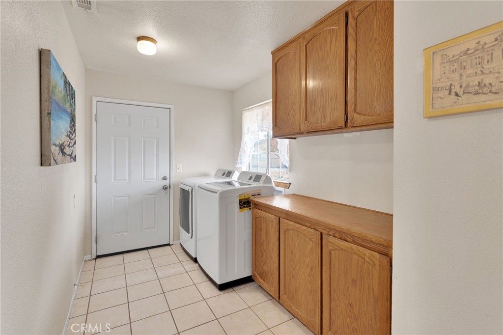 21291 Ramona Road Apple Valley, CA 92307 - Photo 16 of 35 a utility room with cabinets washer and dryer
