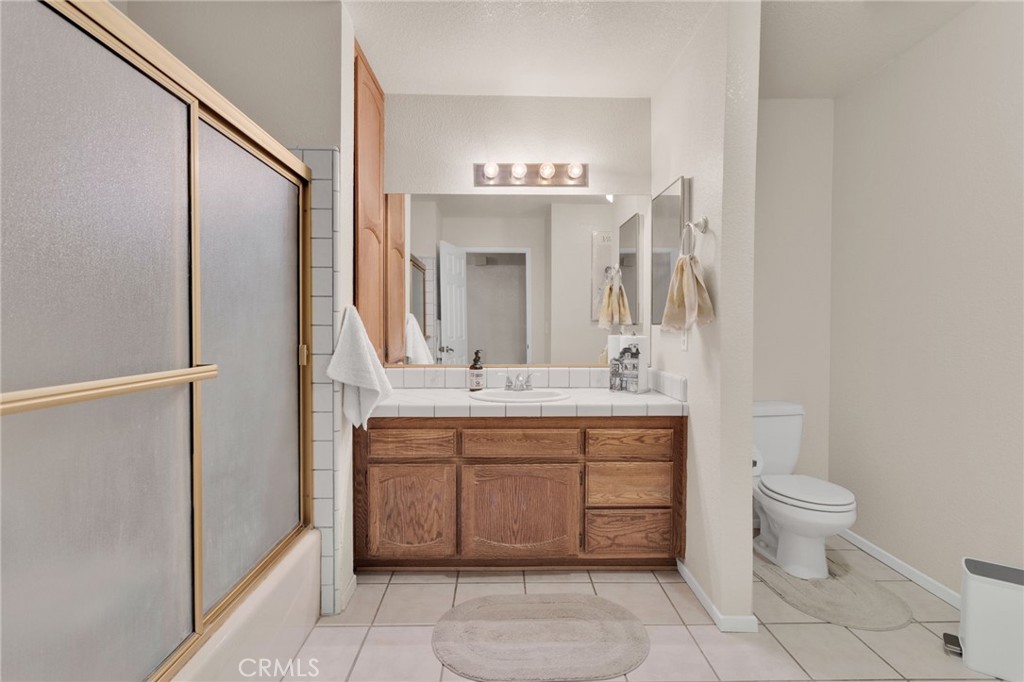 21291 Ramona Road Apple Valley, CA 92307 - Photo 21 of 35 a spacious bathroom with a granite countertop sink a toilet and a mirror