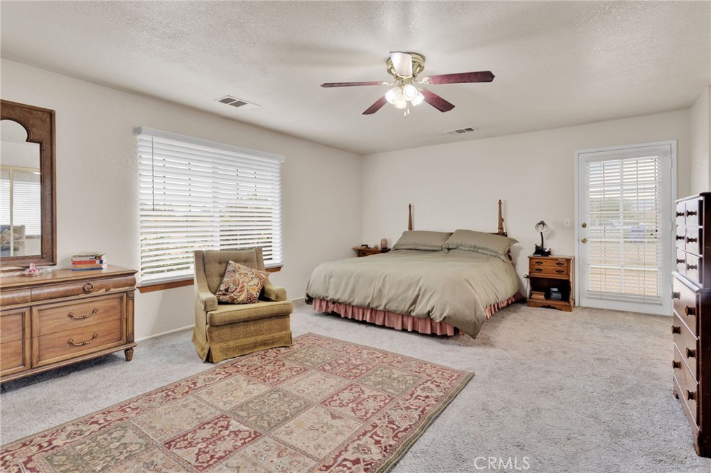 21291 Ramona Road Apple Valley, CA 92307 - Photo 23 of 35 a spacious bedroom with a bed and a couch