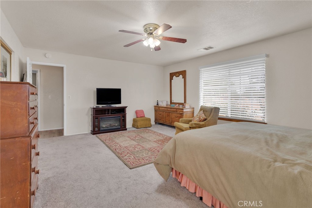 21291 Ramona Road Apple Valley, CA 92307 - Photo 25 of 35 a bedroom with a bed and a flat screen tv