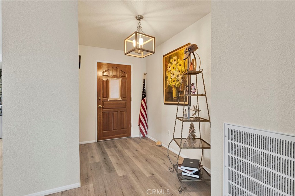 21291 Ramona Road Apple Valley, CA 92307 - Photo 7 of 35 a view of a hallway with wooden floor and windows