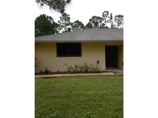 13188 Sand Ridge Road Palm Beach Gardens, FL 33418 - Photo 2 of 7 a front view of a house with garden
