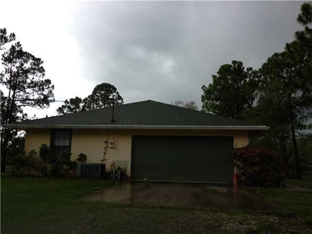 13188 Sand Ridge Road Palm Beach Gardens, FL 33418 - Photo 3 of 7 a front view of a house with garden