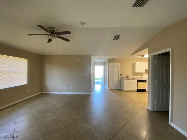 a view of a big room with a windows and a ceiling fan
