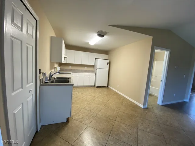 a kitchen with a refrigerator sink stove and cabinets