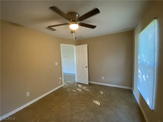 en empty room with closet and a chandelier fan