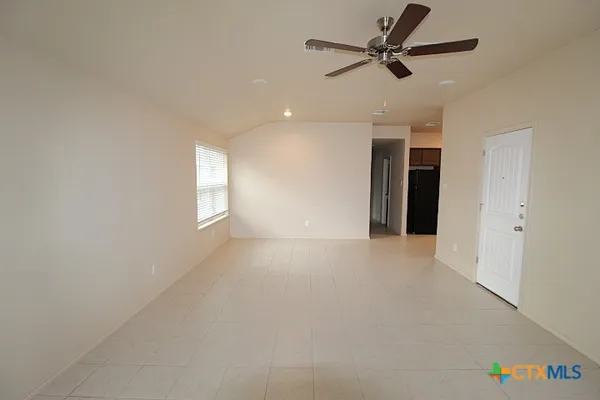 en empty room with windows and fan