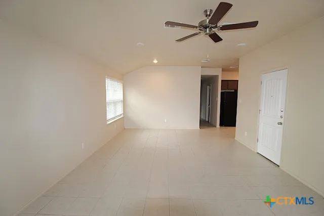 en empty room with windows and fan