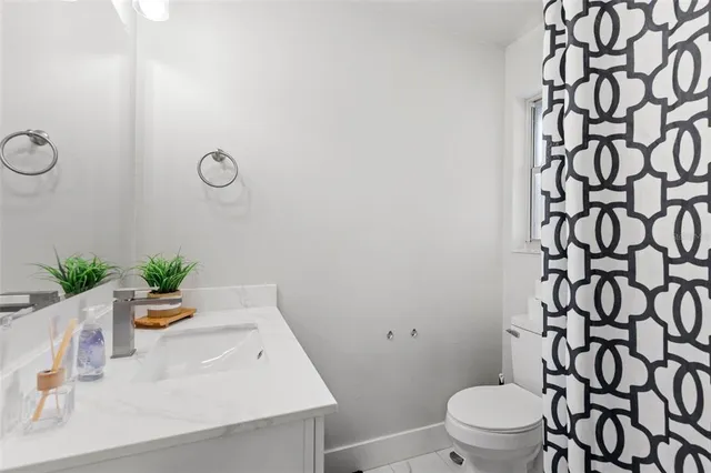 a bathroom with a sink a toilet and shower curtain