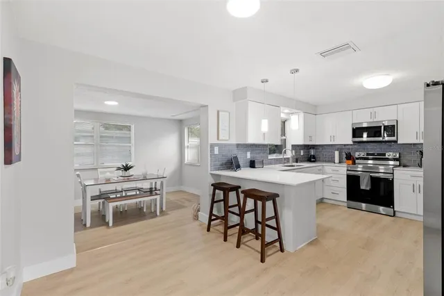 a kitchen with white cabinets and stainless steel appliances