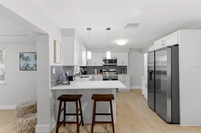 a kitchen with stainless steel appliances kitchen island granite countertop a refrigerator and a stove top oven
