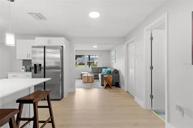 a kitchen view with stainless steel appliances a refrigerator a table and chairs