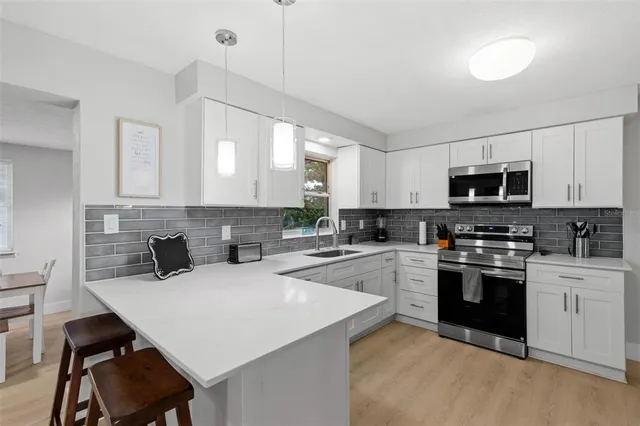 a kitchen with a stove a sink and a refrigerator