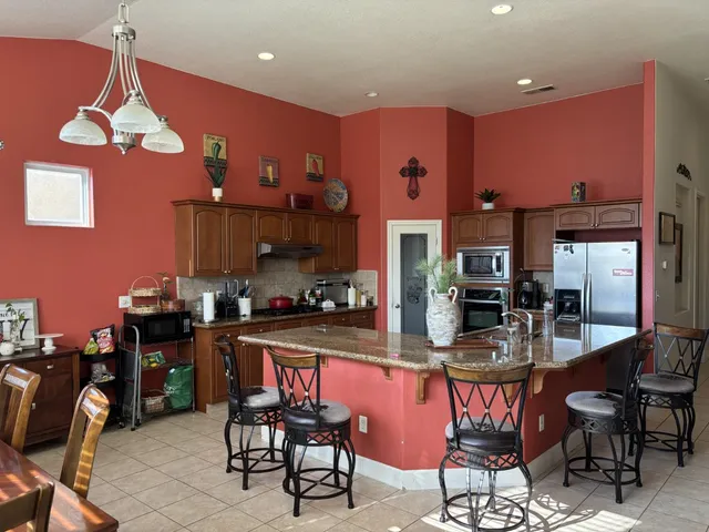 a kitchen with a dining table chairs and granite counter tops
