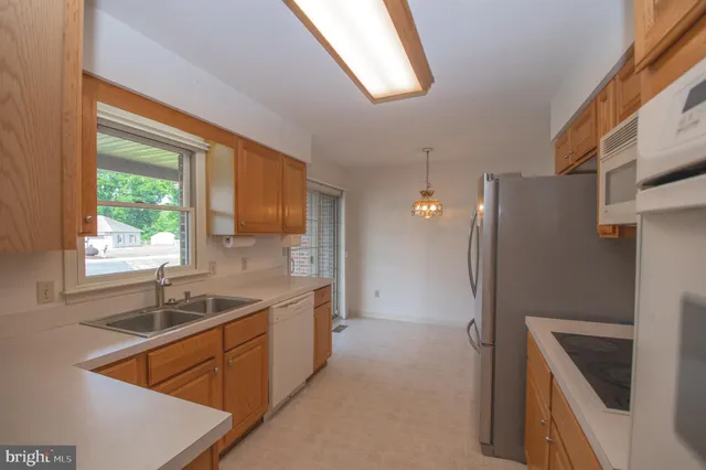 a kitchen that has a sink a refrigerator and window