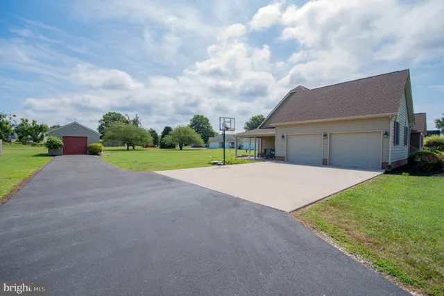 a view of a house with a big yard and a large parking space