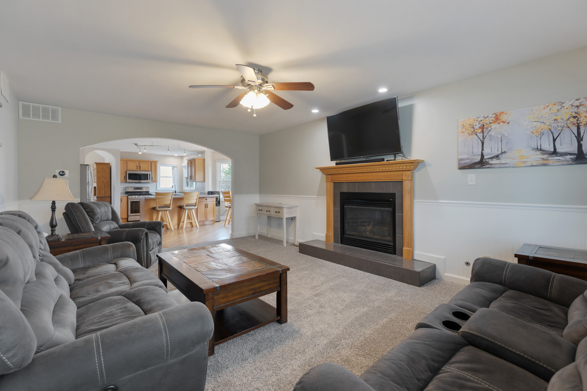 24854 Buttercup Lane Manhattan, IL 60442 - Photo 16 of 36 a living room with furniture a flat screen tv and a fireplace