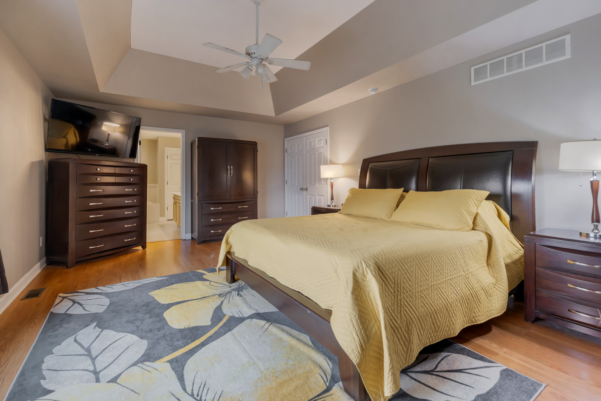 24854 Buttercup Lane Manhattan, IL 60442 - Photo 19 of 36 a bedroom with a bed and a chandelier