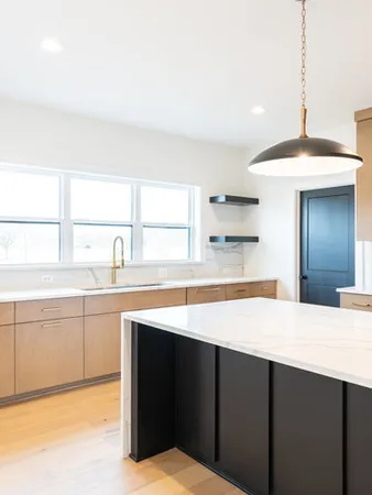 a kitchen with stainless steel appliances kitchen island a sink dishwasher a stove and white cabinets with wooden floor
