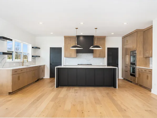 a large kitchen with stainless steel appliances kitchen island granite countertop a stove a sink and a refrigerator