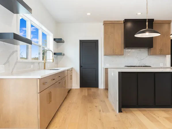 a large kitchen with a sink and a refrigerator