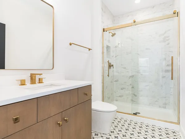 a bathroom with a sink a toilet and shower