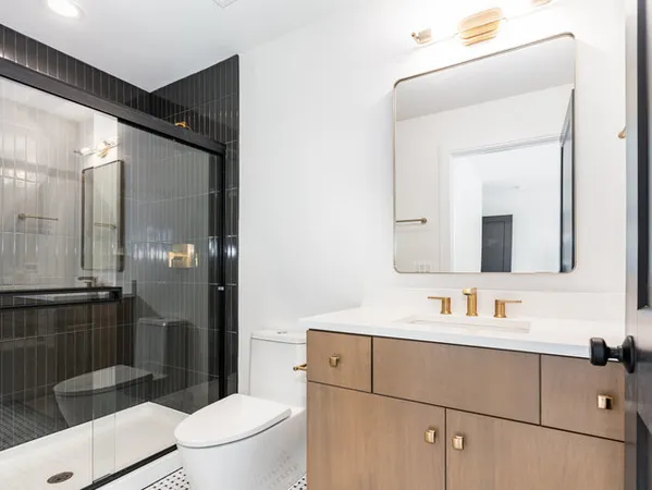a bathroom with a sink a toilet and shower