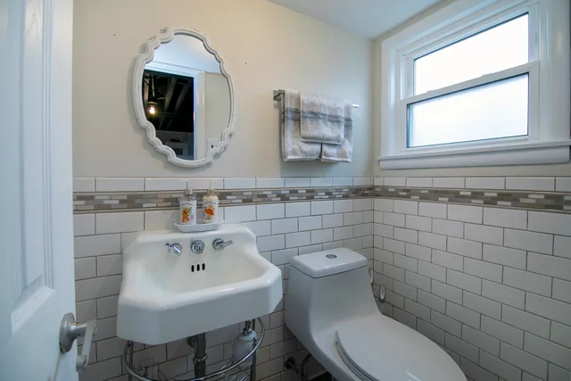 a bathroom with a sink a toilet and a mirror