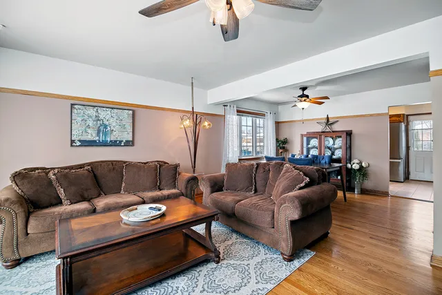 a living room with furniture ceiling fan and a rug
