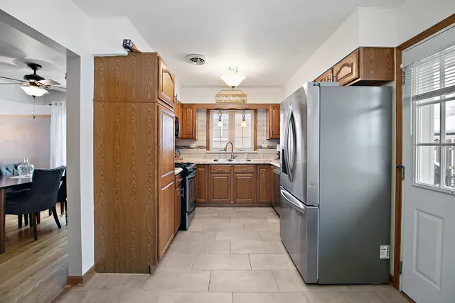 a kitchen with stainless steel appliances granite countertop a refrigerator and a sink