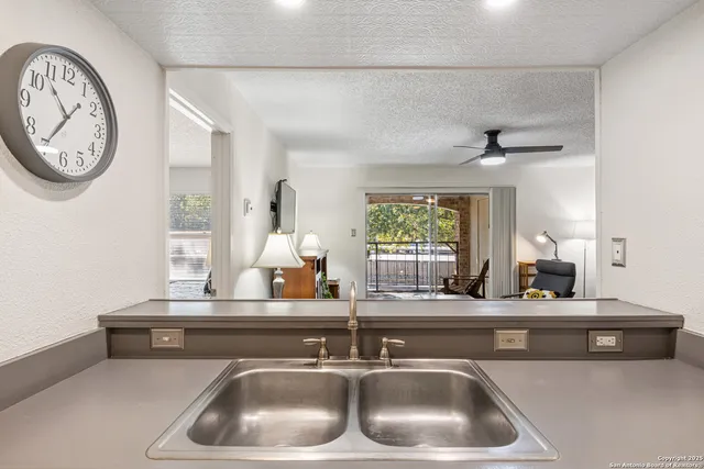 a kitchen with a sink and a clock on the wall